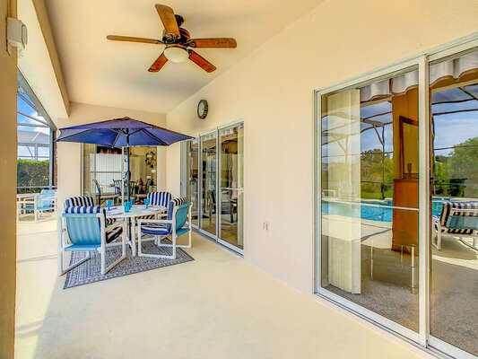 Covered lanai with seating and ceiling fan.