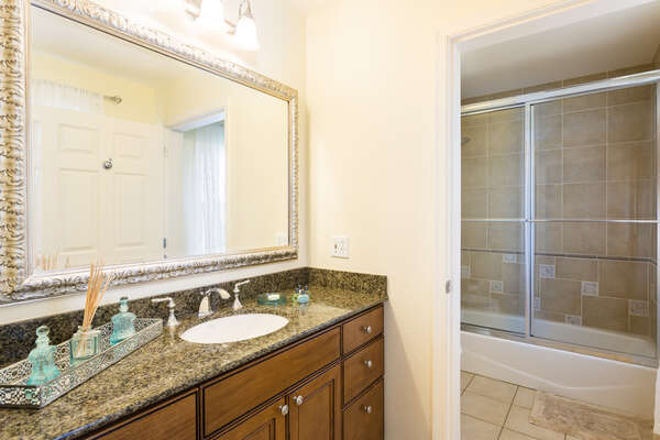 The second bathroom has a tub/shower combination as well as a large vanity mirror and granite counter tops