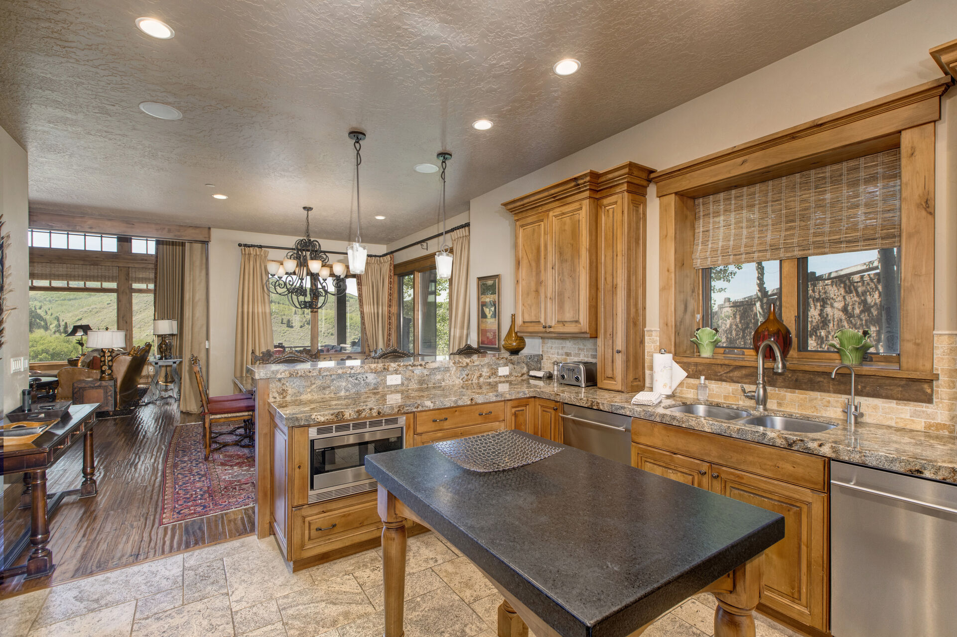 Kitchen with granite island, stone countertops, stainless steel appliances, Wolff stove, walk-in pantry, and bar seating for three
