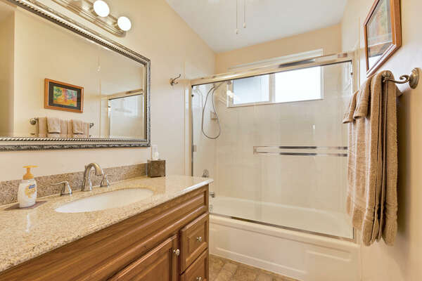 Bathroom 2 with vanity sink and glass-door shower.
