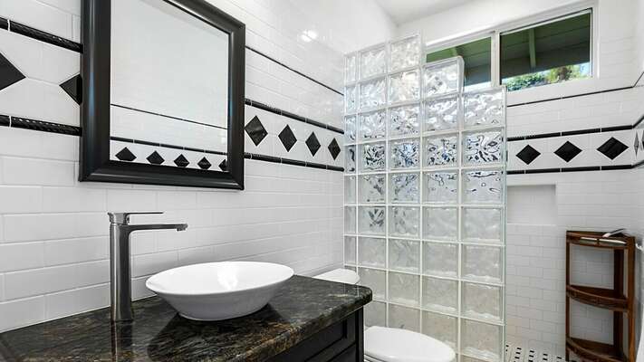 Guest Bathroom 2 with walk-in shower, toilet, and ornate vanity sink.
