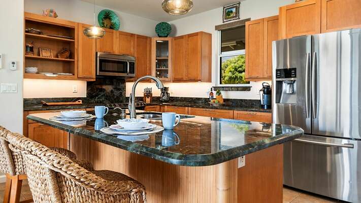 Large Updated Kitchen of this  Kona Hawai'i vacation rental with stainless steel amenities and bar seating by the island.