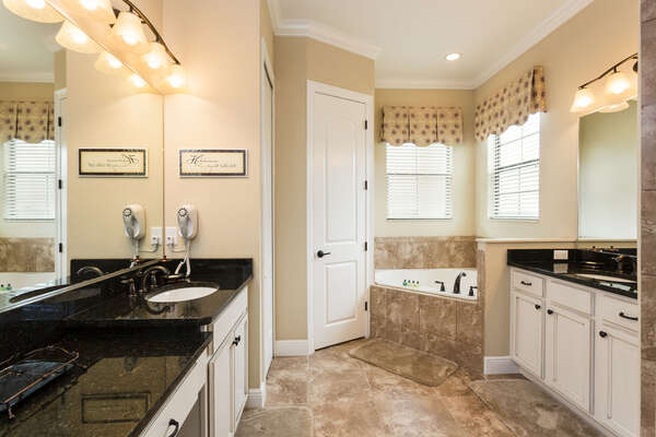 The master bathroom has a large tub, walk in shower and dual vanities