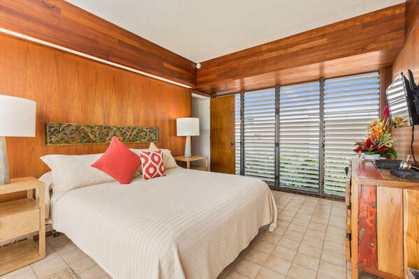 Primary Bedroom of this oceanfront vacation rental with King Bed, wall-mounted TV, and nightstands.