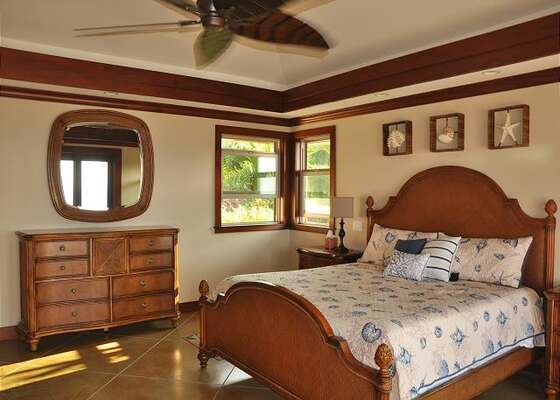 Bedroom with Large Bed, Dresser, and Ceiling Fan