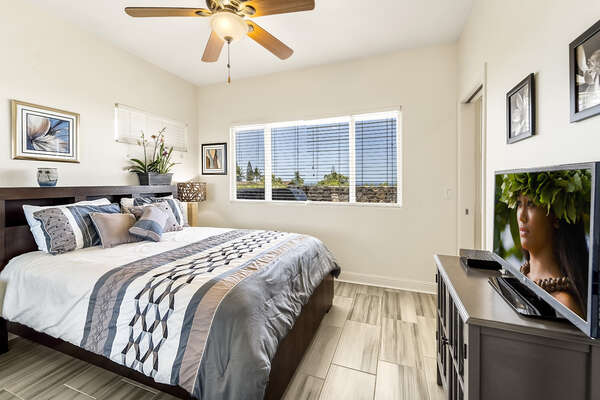 Bedroom with Large Bed, Dresser, Smart TV, and Ceiling Fan