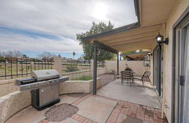 Patio features comfortable dining furniture and an enticing greenbelt view.