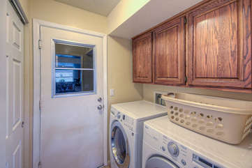 In unit laundry room has family size, front loading appliances and is stocked with detergent.