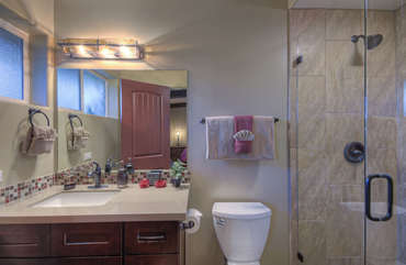 East primary suite bath has a modern tile and glass walk-in shower.