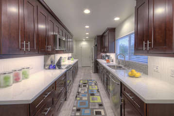 Kitchen has custom cabinets, stainless steel appliances and granite counters.