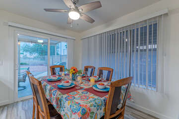 Large windows and sliding doors to the pool and patio bathe the dining area in natural light.