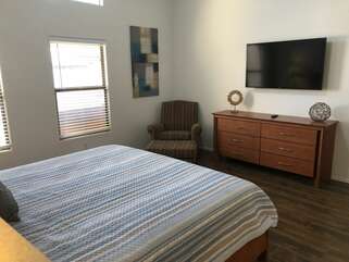 Chic primary bedroom has a king bed, TV, walk-in closet and ensuite bath.