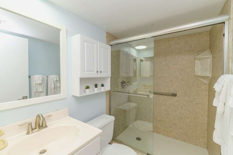 A bright and contemporary bathroom with a spacious glass-enclosed shower for a refreshing experience.