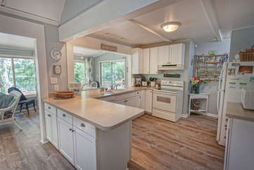 Kitchen in a square shaped room, with ample counter space and modern appliances.