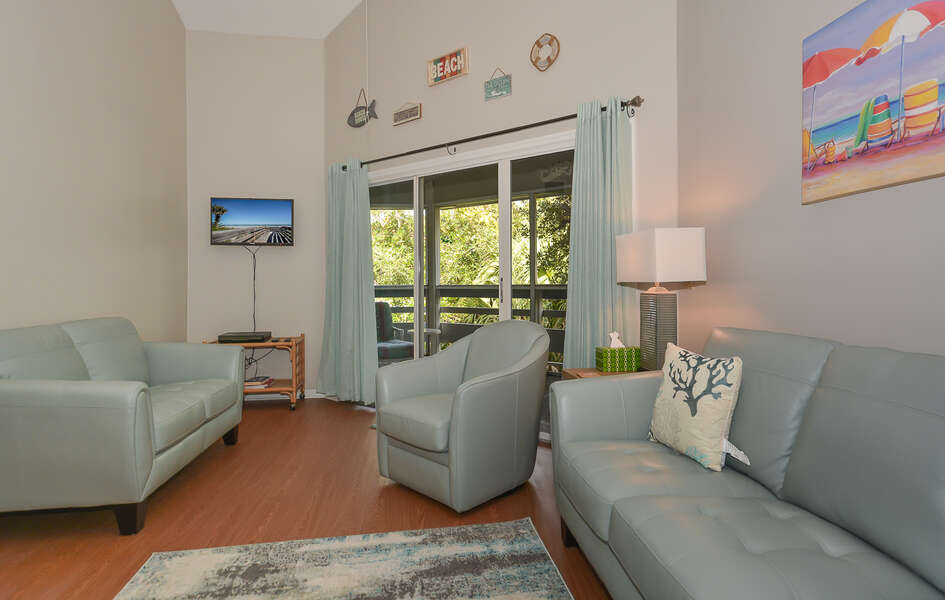 Bright roomy living are with flat screen TV.