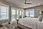 Many windows bring in great lighting and wonderful views to this bedroom.