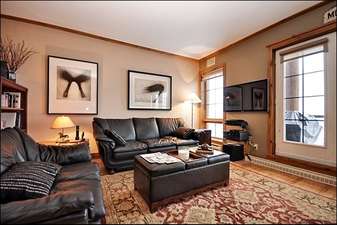 Living Room has Stunning Hardwood Floors and Leather Couches
