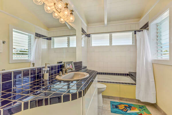 Unique blue tile highlights the vanity sink and tub of an upper level bathroom 2.