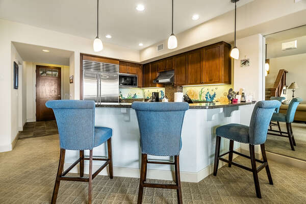 Fully equipped kitchen breakfast counter and stainless steel appliances.