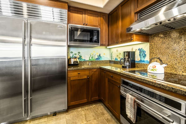 Massive stainless steel fridge, microwave, and oven range in the kitchen of this Kona Hawaii vacation rental.