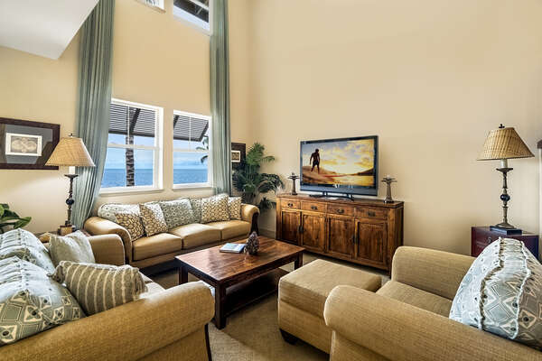 Comfortable seating in the living area, with two couches, armchair, and a flat-screen TV on an entertainment center.