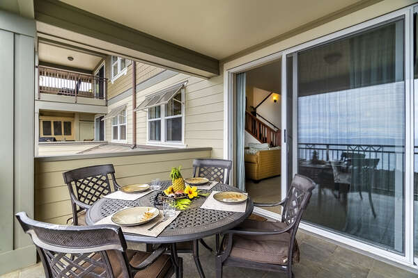 The main lanai with table and seating , in front of sliding glass door inside.
