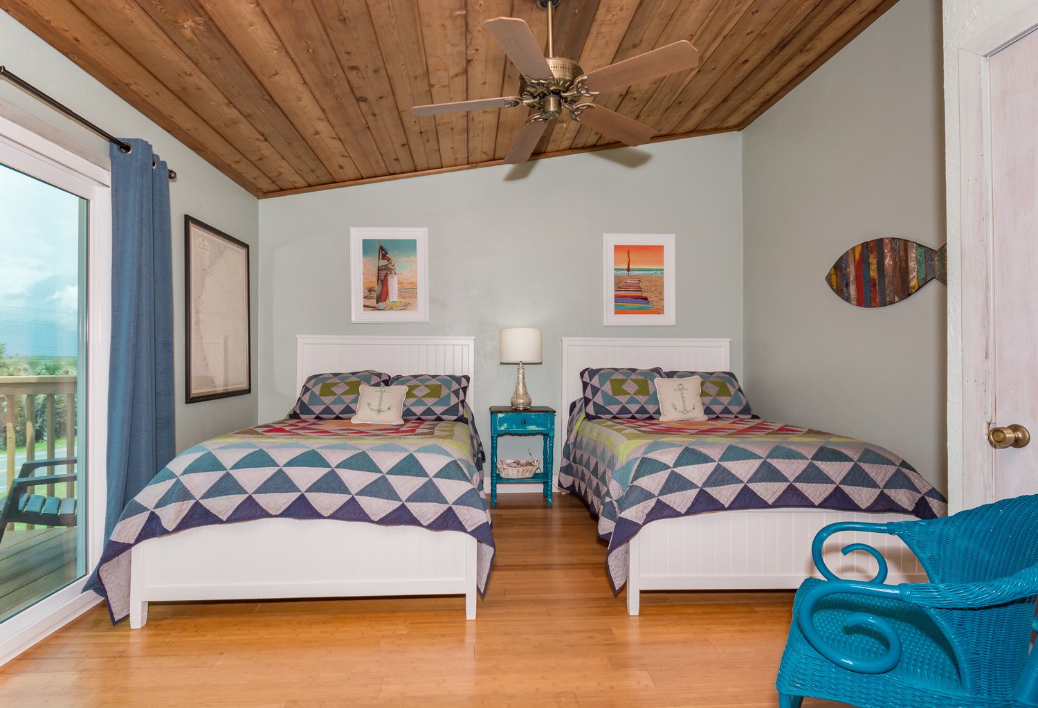 2nd level guest room of this New Smyrna Vacation Home with 2 full beds and colorful sheets.