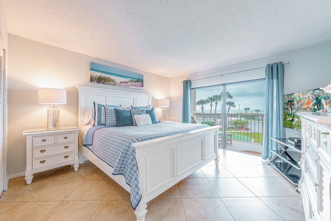 Serene master bedroom with king size bed and a private balcony view.