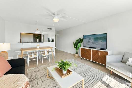 Bright and upgraded living and dining room with a big screen TV and seating for six.