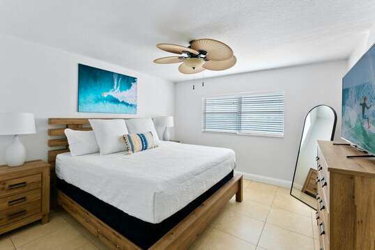 Guest bedroom with a king bed and big screen TV.