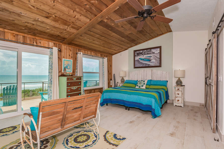 3rd level oceanfront master bedroom of this New Smyrna Vacation Home with king sized bed and flat-screen TV.