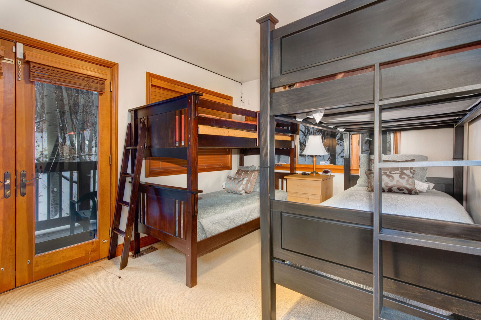 Bedroom 3 with Two Twin over Twin Bunk Beds and a Private Deck with Quiet Wooded Views