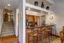 Kitchen with stone countertops, stainless steel appliances, ice maker, and bar seating for four