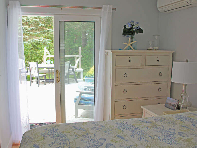 The bedroom offers glass sliding doors to the back deck - 425 Paines Creek Brewster Cape Cod - New England Vacation Rentals