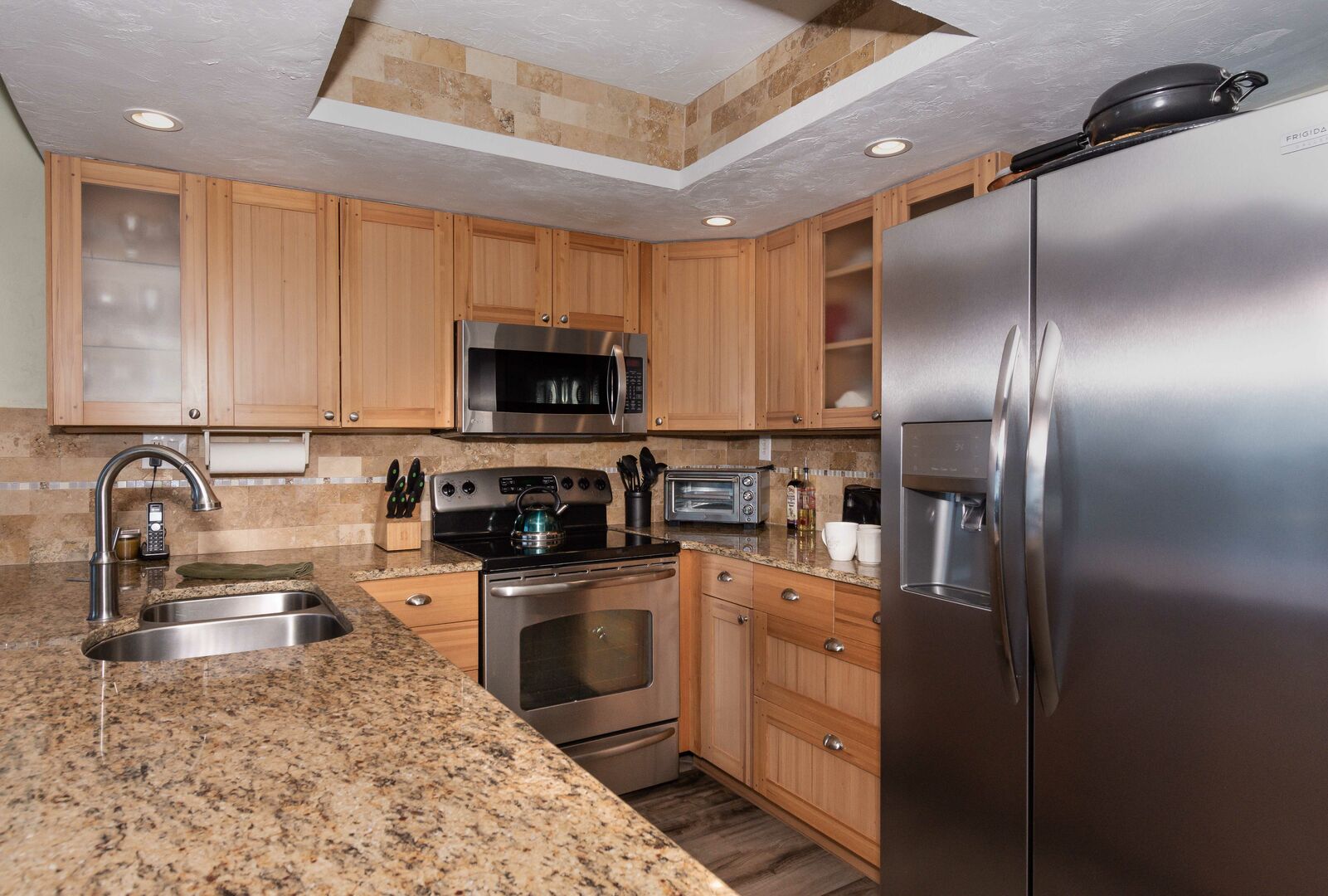 Open kitchen of this vacation condo in New Smyrna Beach with granite counter tops and stainless steel appliances.