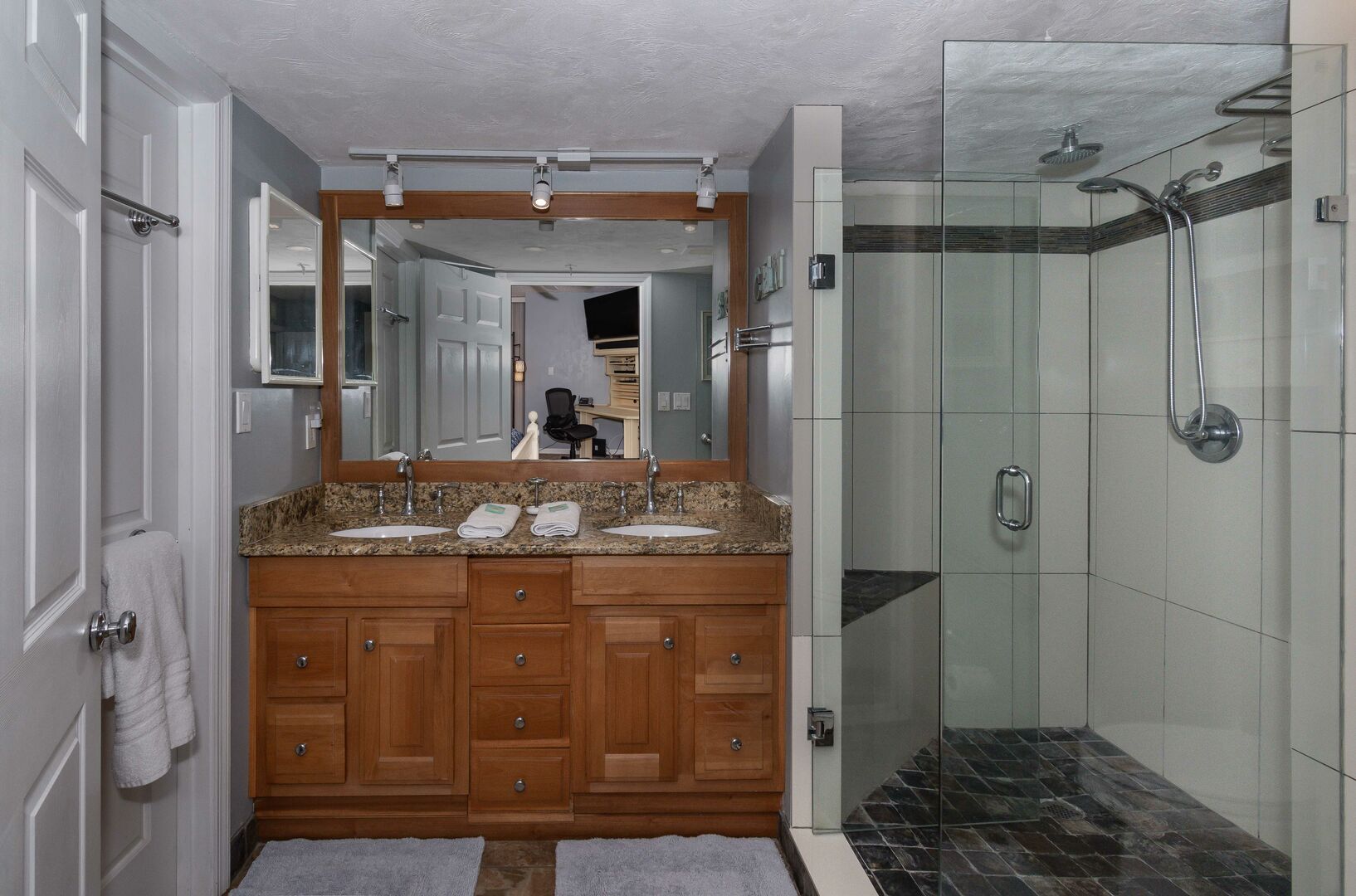 Master bath with walk-in shower and large mirror sink.