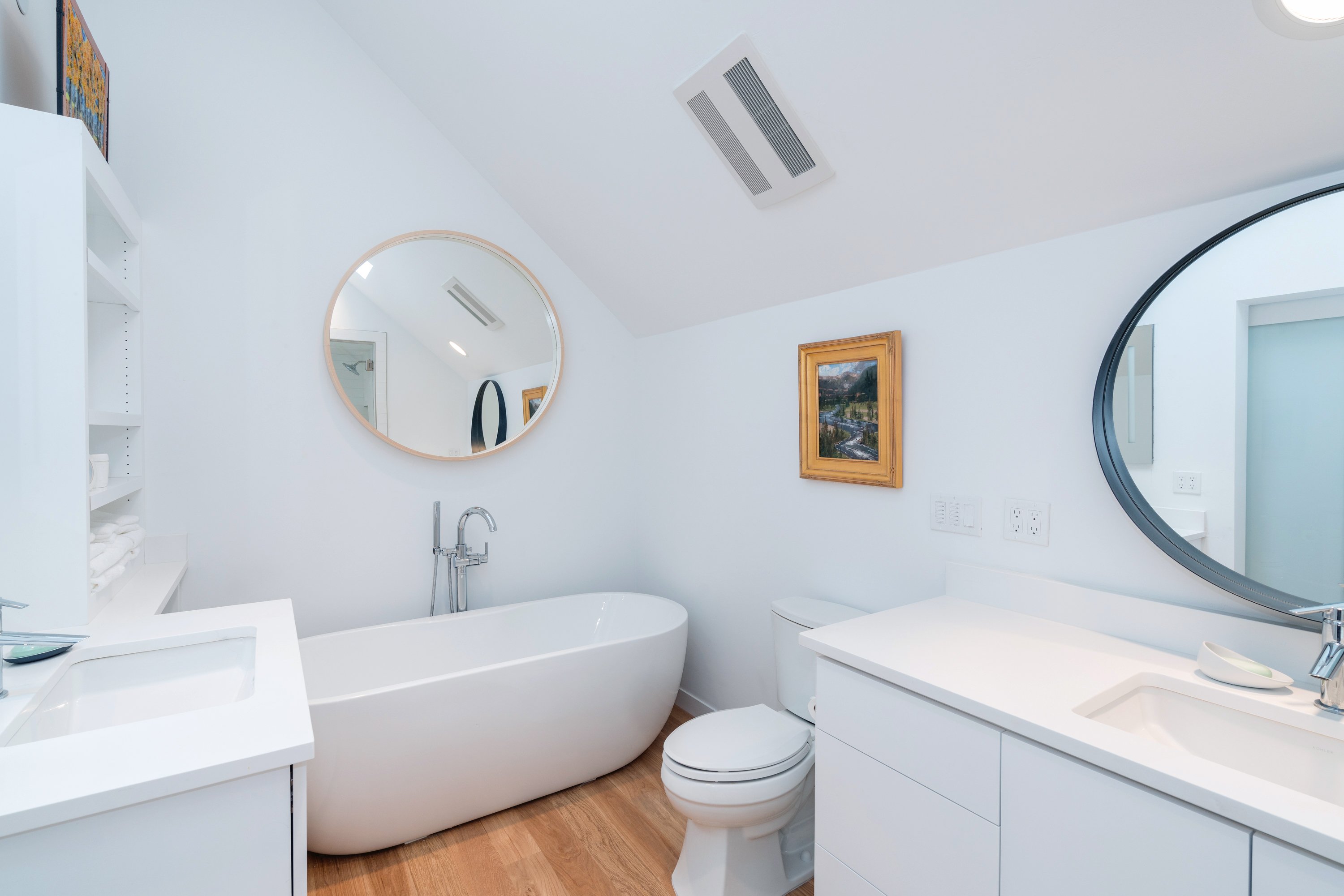 Bathroom with Soaking Tub and Vanity with Round Mirror