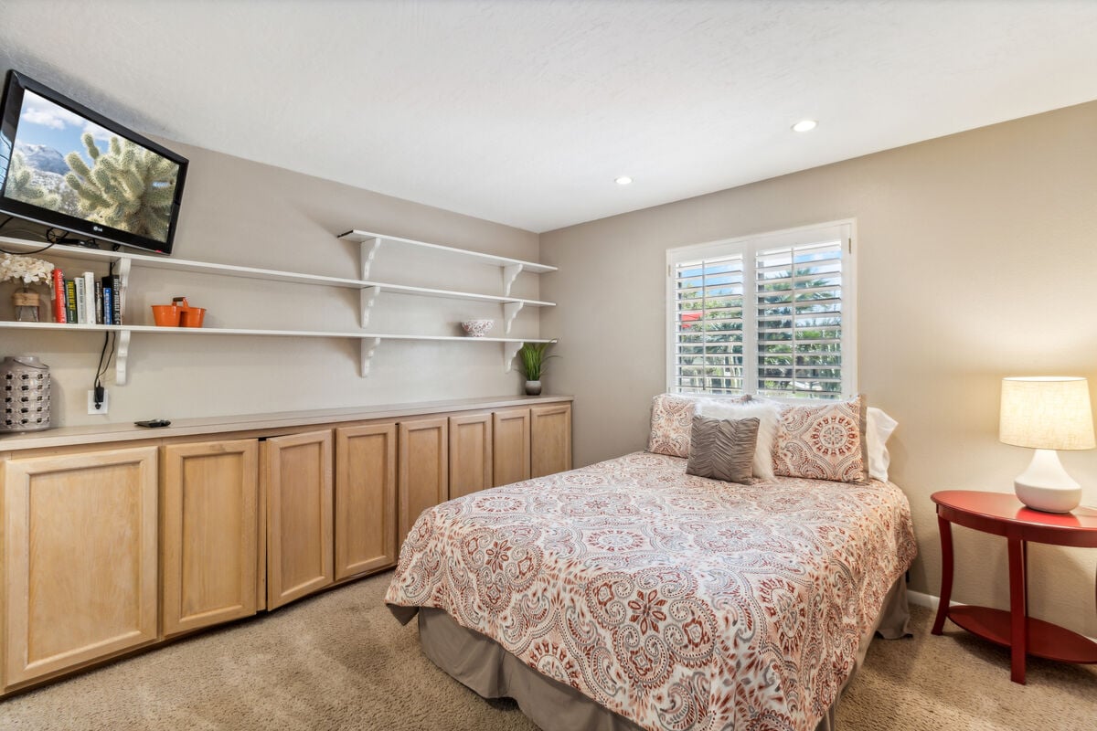 The cozy second bedroom has a nice ambiance with dedicated work space built into the closet!