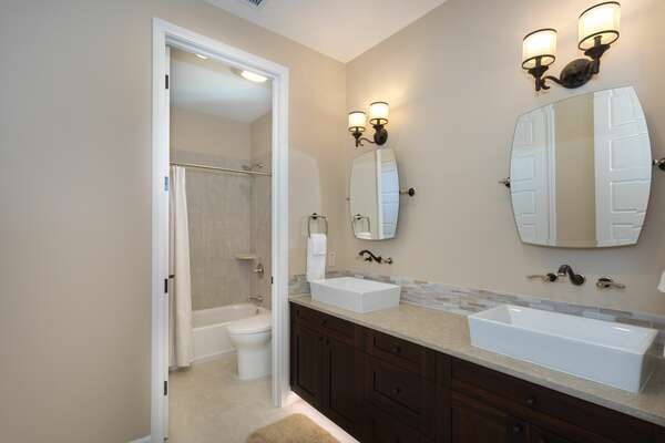 The double vanity sinks in bathroom 2, with a separate shower and toilet room.