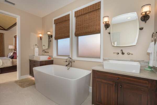 The master bathroom of this Kona Hawaii vacation rental with vanity sinks and large tub.