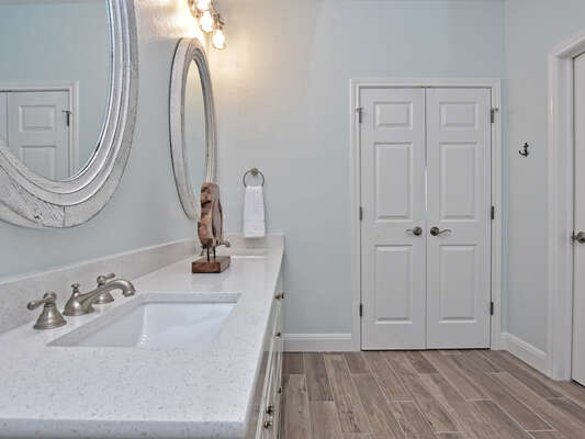 Double vanity in the en-suite bathroom attached to the Primary Bedroom with a walk-in closet to the right.