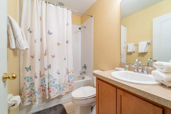 En-suite bathroom for master bedroom 1.  Has bath/shower combo and single basin vanity