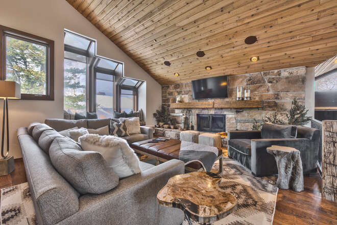 Upper Level Living Room with Cozy Mountain Contemporary Furnishings, a Smart TV and a Gas Assist Wood Fireplace