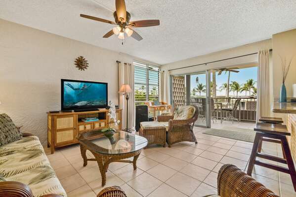 Living Area of this Kona condo for rent with couch, chairs, and TV.