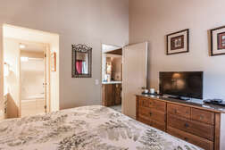 Master bedroom (downstairs) with King size bed, flat screen TV, and full master bath en-suite
