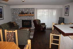 Living room with gas fireplace, flat screen TV, large section couch/sofa sleeper, and private outdoor patio