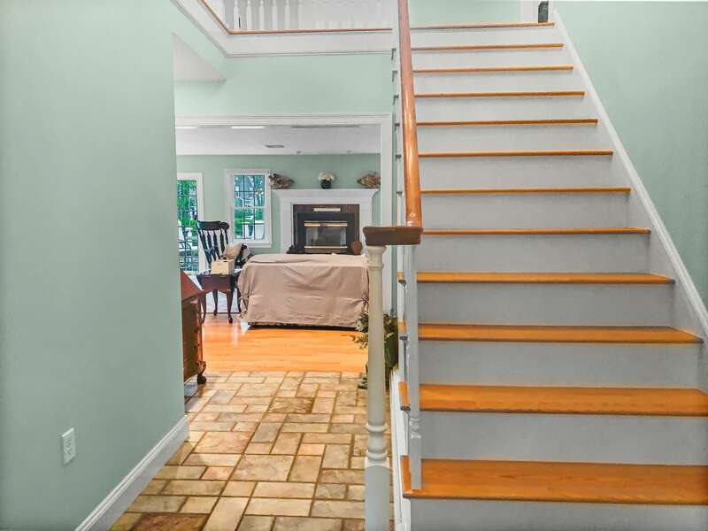 Main stairway to the 2nd floor and a view of the living area - 2 Mashpa Road Harwich Cape Cod - New England Vacation Rentals  #BookNEVRDirectHarwichFamilyTides