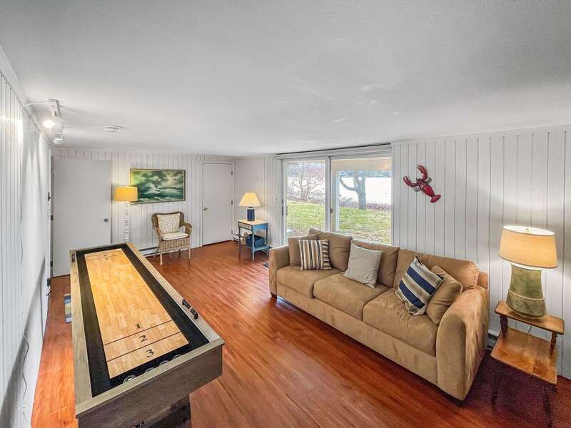 Lower level game room with combination shuffle board/bowling table and sliding door to the backyard - 84 Cranberry Lane Chatham Cape Cod - Ridgevale Retreat