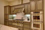 Chef's kitchen with stainless steel appliances and double oven.