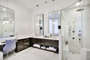 Bathroom with several mirrors and walk in shower